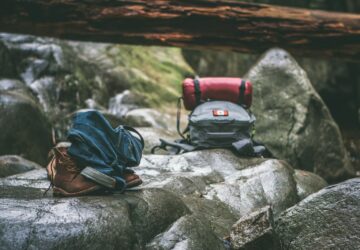 two gray and orange backpacks on gray rocks at daytime